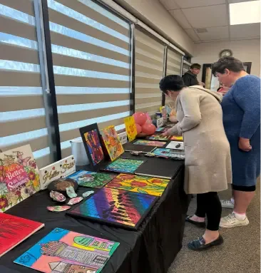 Visitors viewing client artwork on display at the Art Program Exhibit