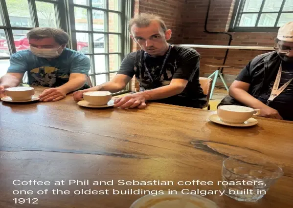 Clients enjoying coffee at Phil and Sebastian Coffee Roasters in a historic Calgary building
