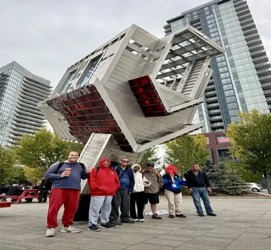 The group in front of the Device to Root Out Evil sculpture in Calgary