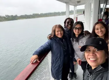Staff and clients smiling on the deck of the Heritage Park boat ride