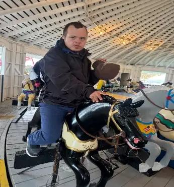 A client enjoying a ride on the Heritage Park carousel