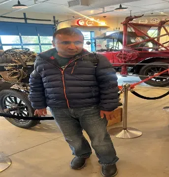 A client standing beside the vintage car exhibit at Heritage Park